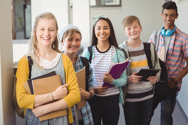 group-of-smiling-students-standing-with-notebook-i-A5KKV2L
