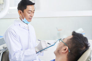 asian male dentist at work D9DE6XX