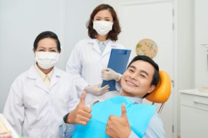 smiling patient and doctors in dental office 932G46R
