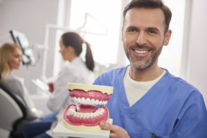 smiling dentist showing an artificial dentures 2021 08 30 02 27 19 utc 1