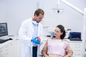 dentist showing model teeth to patient 2021 08 28 16 45 09 utc 2